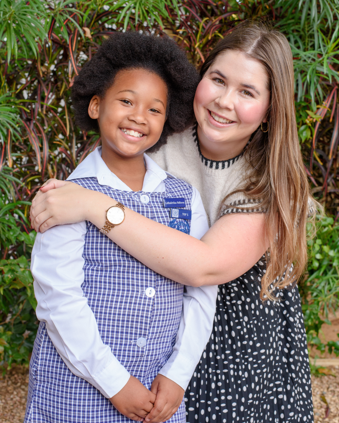 A Hamptons teacher hugging a proud pupil