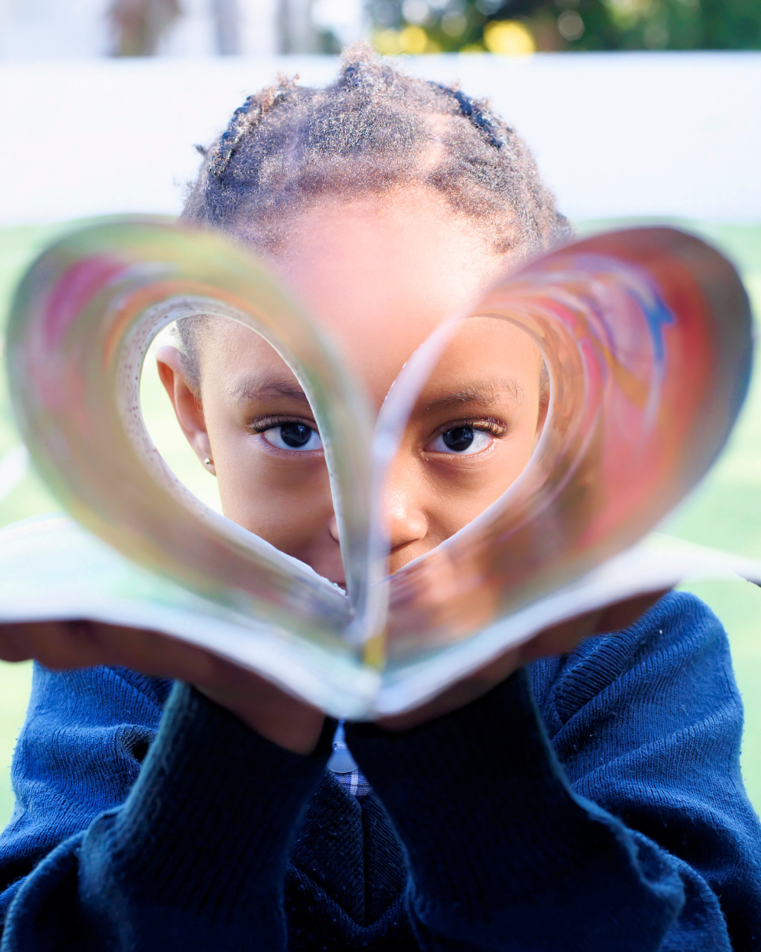 A Hamptons pupil peeking through a book folded into a heart