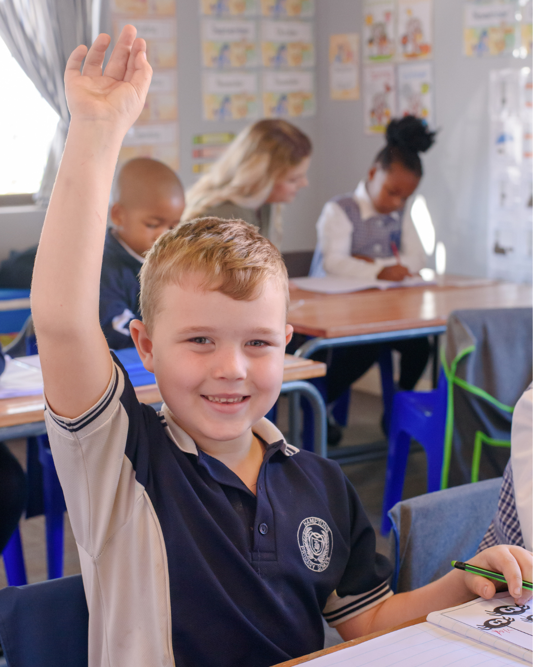 A Hamptons pupil eagerly raising his hand in class